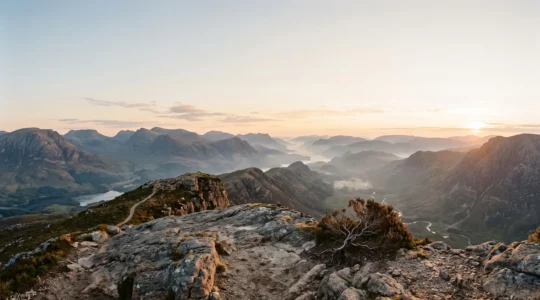 Vue panoramique spectaculaire depuis un promontoire rocheux isolé en montagne, au lever du soleil, sans aucun touriste visible