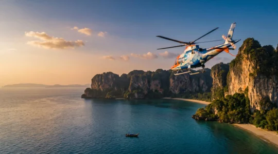 Hélicoptère médical survolant une côte tropicale thaïlandaise au coucher du soleil, symbolisant l'urgence et la sécurité d'un rapatriement sanitaire